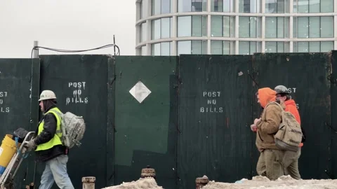 Construction workers walking past site post no bills sign New York City NYC 스톡 동영상 148344147