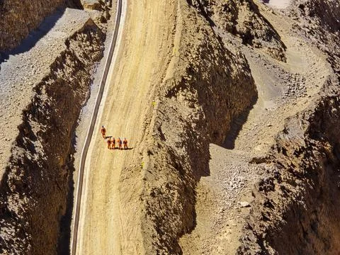 Construction workers walking on sidewalks in an open-pit mine Stock Photos