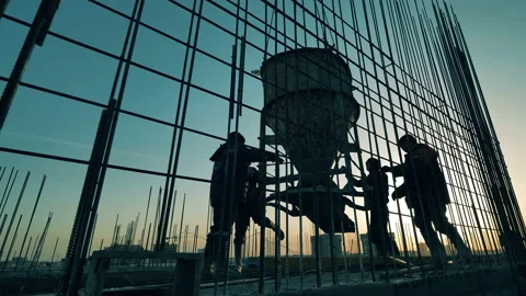 Construction workers watch a crane moving concrete container. Video stock 131197508