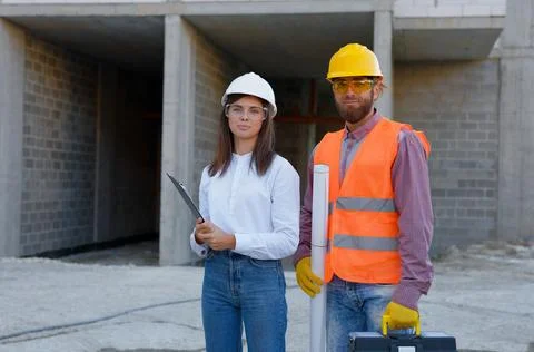Construction workers wearing safety gear at building site Stock Photos
