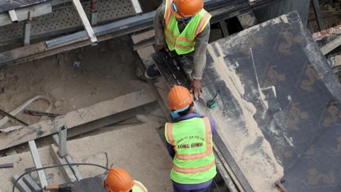 A construction workers wearing safety vests and helmets working on a building Stock Footage 315430199
