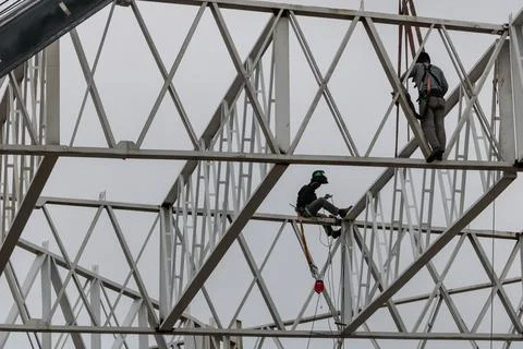 Construction workers who work suspended in a metal frame Foto stock