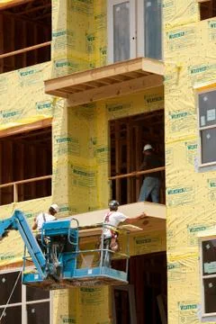 Construction workers work on balcony at condo housing development Stock Photos