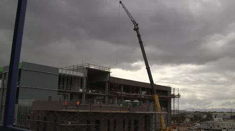 Construction workers work on industrial building - crane in background Stock Footage 48827113