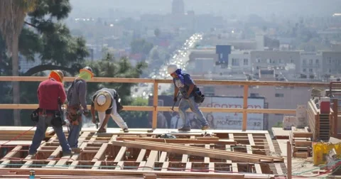 Construction workers working on high storeys apartment building site in LA Stock Footage