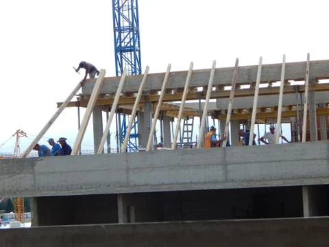 Construction workers working on the roof construction of new residence building Stock Photos