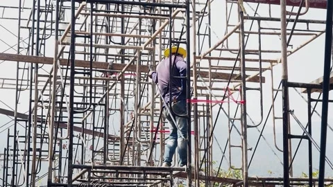 Construction workers working on scaffolding in a building site. Stock Footage 151887033