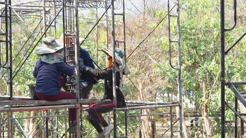 Construction workers working on scaffolding in a building site. Stock Footage 156542073