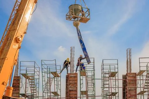 Construction workers working on scaffolding at a high level by the standard.. Stock Photos