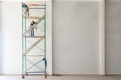 Construction workers working on scaffolding, Man filling silicone for seali.. Stock Photos