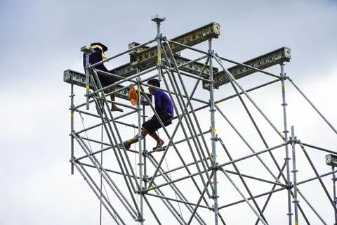 Construction workers working on scaffolding men working Stock Photos