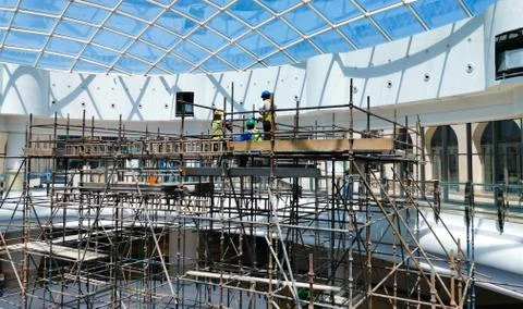 Construction workers working on scaffolding. Stock Photos