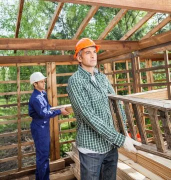 Construction Workers Working In Timber Cabin At Site 写真素材