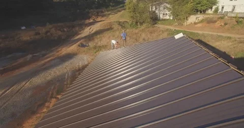 Construction workers working on top of a roof (drone) Stock Footage 107322046