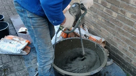 Construction Working Mixing Cement in Bucket with Concrete Mixer Stock Footage 109107881
