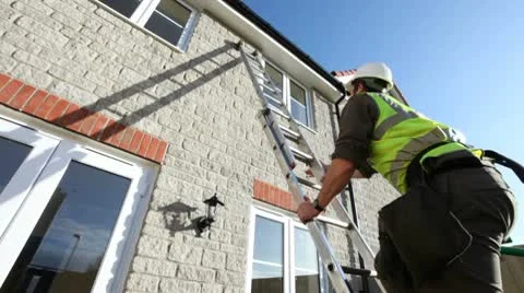 Construction. Workman climbing ladder on new build house. Stock-Footage 9245067