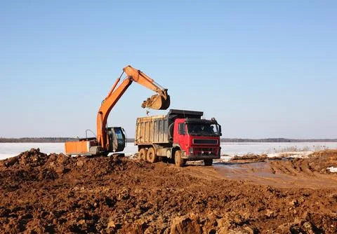 Construction - Yellow Excavator behind dump truck work Foto stock