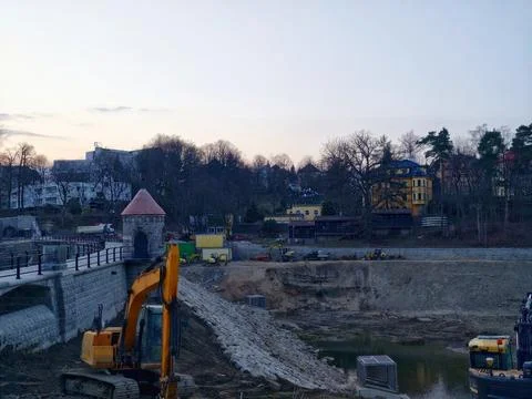 Construction Zone During Evening With Heavy Machinery Creating Embankments .. Stock Photos