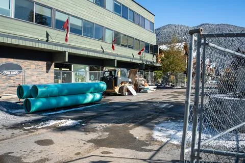 Construction zone showing large teal pipes and construction equipment. Stock Photos