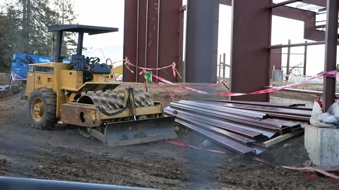 Construction Zone Through Fence With Heavy Machinery and Building Material Pile Stock Footage 102416036