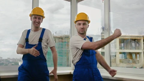 Constructiona workers in helmets comic dancing looking to camera. Stock Footage 117262782