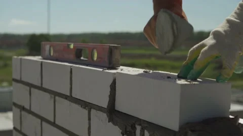 Construction.Construction of a multi-storey building.The Builder lays bricks Stock Footage 144159438