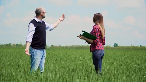 Constructive discussion of farmer partners with documents standing in middle of Vidéo 108745181
