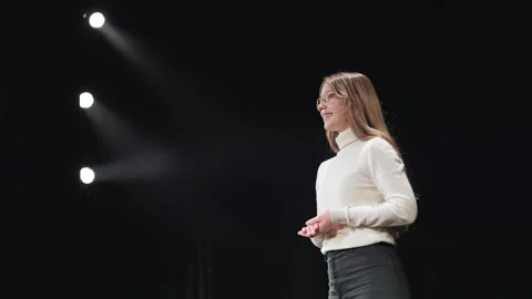 Constructive female advisor standing on stage with spotlight Video stock 241511449