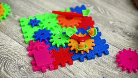 Constructor building process with bright gear pieces connected on plastic base Vídeos de archivo 339419035