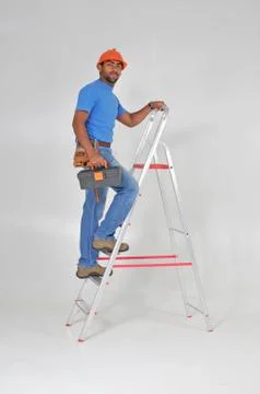 Constructor on the ladder with tools 스톡 사진