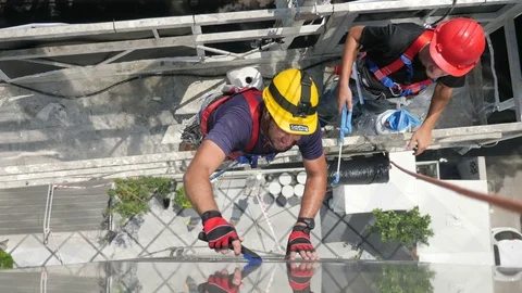 Constructor worker with yellow helmet install window film Vídeo Stock 80555095