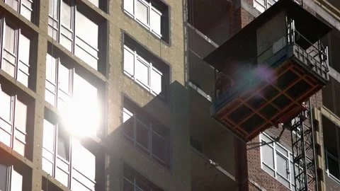 Constructruction workers on the elevator are moving down. Video stock 194933256