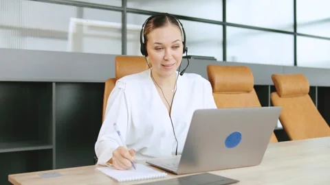 Consultant assists clients through a call center at a modern office workspace Stock Footage 320945964