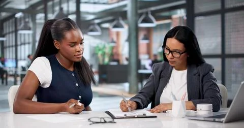Consultant Carefully Reviews Documents While Helping Woman Fill Important For Stock Photos