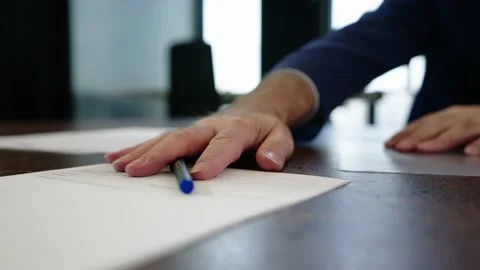 Consultant pushes a contract over to a client to sign it, after he is done Vídeo Stock 153613308