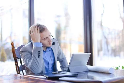 Consultant speaking with client at cafe using tablet and headset 스톡 사진