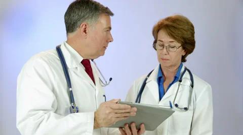 Consulting doctors review data using a tablet pc Stock Footage 33822513