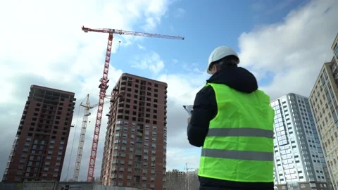 Consulting engineer at construction site holding blueprint in hand. Construction Stock Footage 168482179
