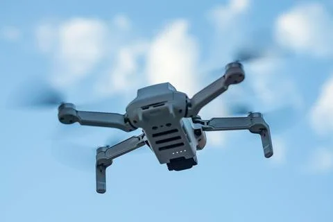 Consumer drone with camera hovering against sky Stock Photos