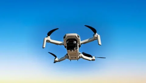Consumer drone with camera hovering against sky Foto stock