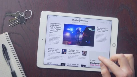 Consumer reading The New York Times app on iPad Stock Footage