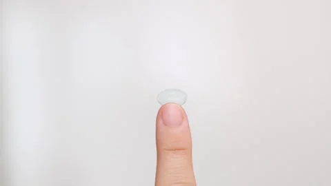 Contact lens solution pouring on lenses on woman finger. Stock Footage 247173380