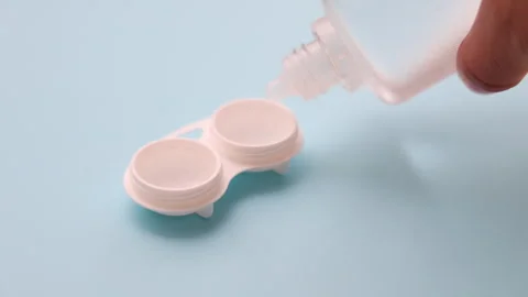 Contact lens solution pouring on lenses on woman finger. Stock Footage 247173589