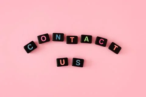 Contact us button concept. Black beads on pink background making word Stock Photos