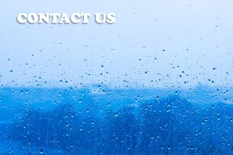 CONTACT US text on rain drops window glass blue background Stock Photos