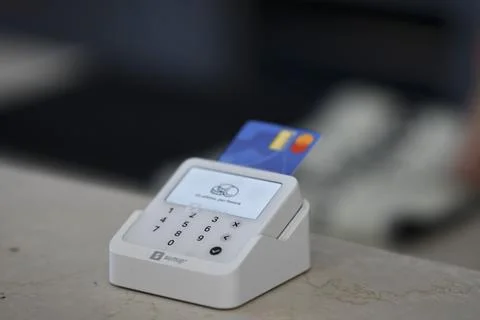 Contactless payment processing, credit card inserted in SumUp terminal at bar 스톡 사진