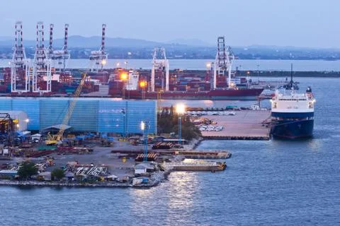 Container and crane in shipyard on the sea at twilight Stock Photos