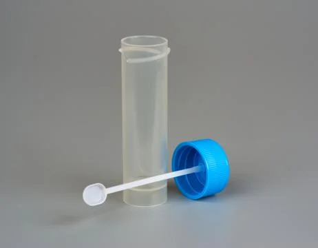 Container for biomaterial with spoon on gray background Stock Photos