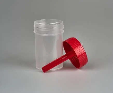 Container for biomaterial with spoon on gray background Stock Photos