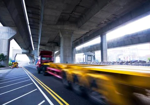 Container car fast moving under the freeway bridge Stock Photos
